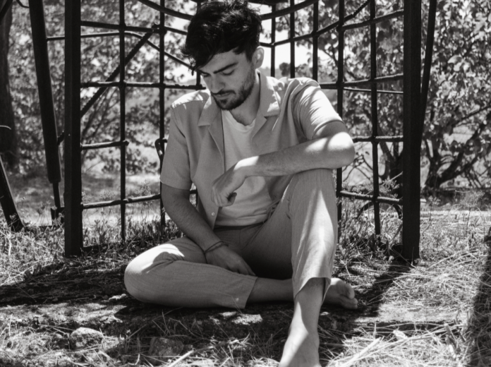 hesanobody appoggiato a una ringhiera, in una foto in bianco e nero