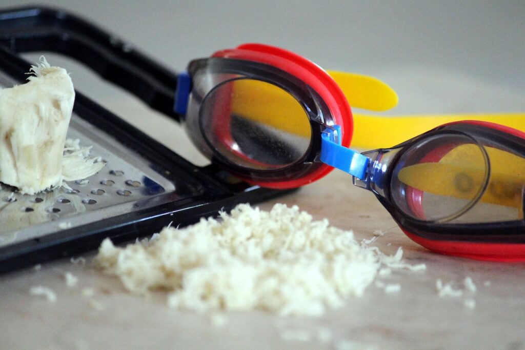 Radice grattugiata con occhialini protettici accanto.