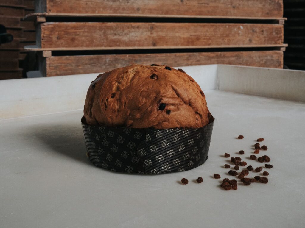 un panettone con tante gocce di cioccolato sparse sul tavolo dove è appoggiato