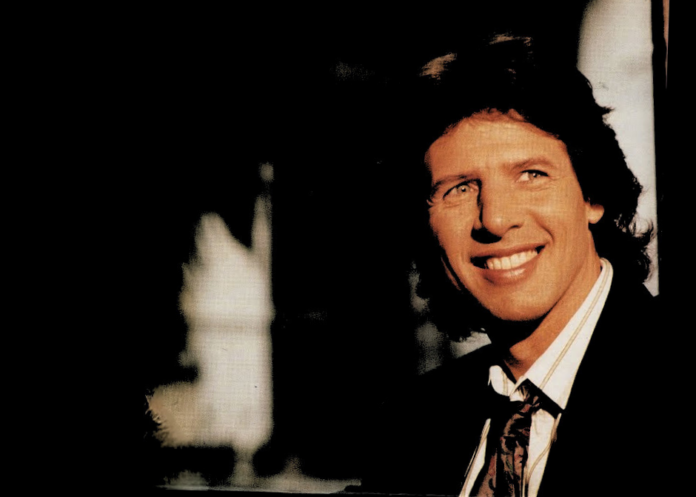 Sandro Giacobbe addio a un gentiluomo tra le note - Zetatielle Magazine Sandro Giacobbe sorride, indossa giacca , camicia bianca e cravatta scura, su sfondo nero