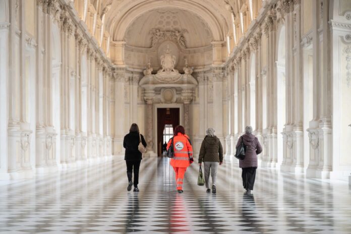 Al museo con la prescrizione del medico il nuovo grande progetto di arte e cultura - Zetatielle Magazine - Venaria_1 Al museo con la prescrizione del medico il nuovo grande progetto di arte e cultura - un grande corridorio dell areggia con delle persone di schiena che cmminano