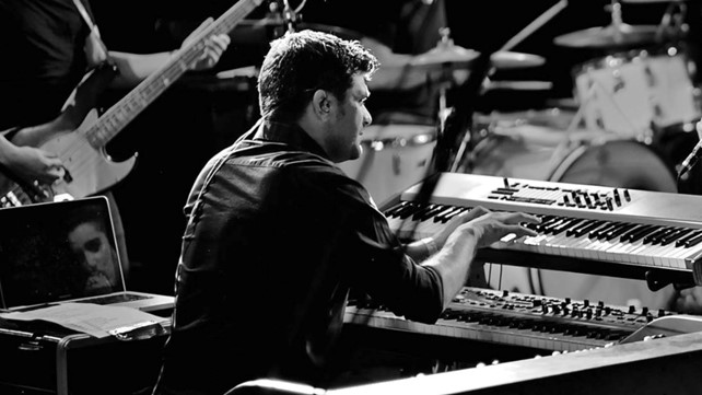 alessandro orefice di spalle intento a suonare le tastiere