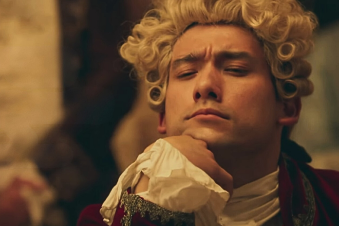 Amadeus, la serie TV che convince a metà. Recensione - Zetatielle Magazine - screenshot da video trailer youtube Amadeus, la serie TV - screenshot da video youtube con il volto di MOzart in primo piano con parrucca bionda a boccoli, ha la mano appoggiata al mento con polsino di pizzo, ha un'aria perplessa e riflessiva
