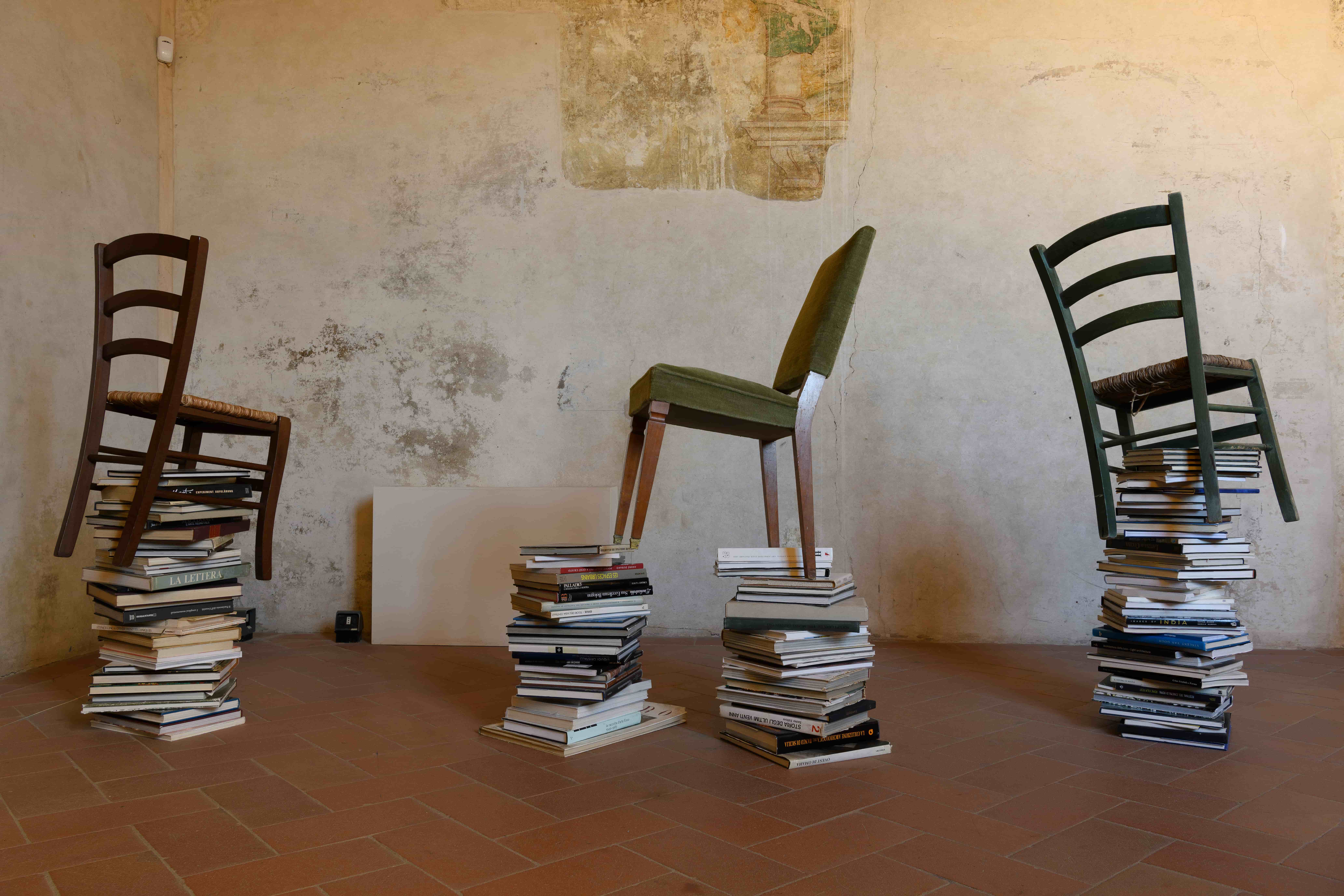 fiammetta - nella foto un'opera di valentina palazzari, ovvero delle sedie appoggiate su delle pile di giornali e riviste