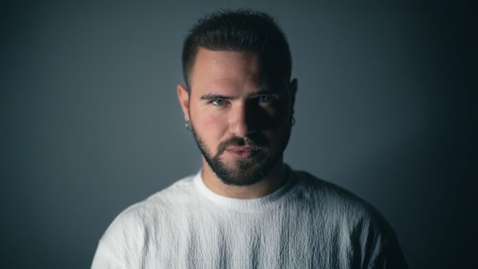 marco la cerenza - la pista - il caantautore in primo piano, indossa un maglioncino bianco