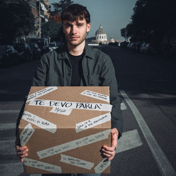 mash in primo piano, tiene in mano uno scatolone di cartone