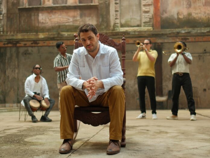 neapolis mambo - walter ricci seduto su una sedia in un cortile circondato da musicisti