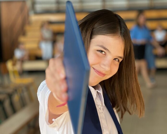 Patentino delle competenze digitali via al progetto nazionale gratuito per gli studenti - nella foto una bambina sorridente tiene con la mano destra alto un certificato
