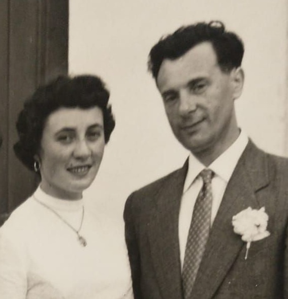 Foto in bianco e nero con giovane coppia a mezzo busto, il giorno del matrimonio. A destra, Rando Bertoia, in giacca e cravatta e fiore bianco all'occhiello. A sinistra, vestita di bianco, la moglie Giovanna.