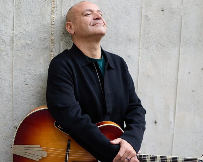 MICKI lancia “Verrà” tra pop d’autore e suggestioni jazz - Zetatielle Magazine micki in primo piano appoggiato a un muro, ha la chitarra a tracolla