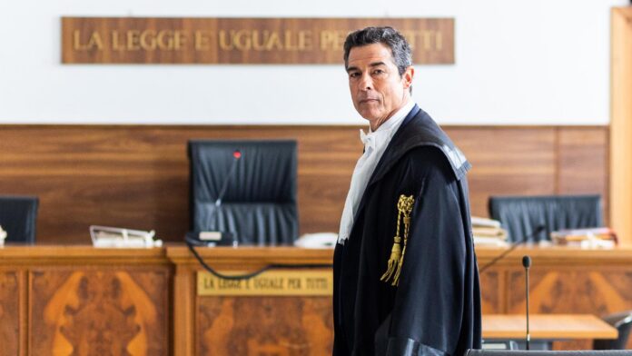 guerrieri - alessandro gassmann con la toga da avvocato, in primo piano in un'aula di tribunale