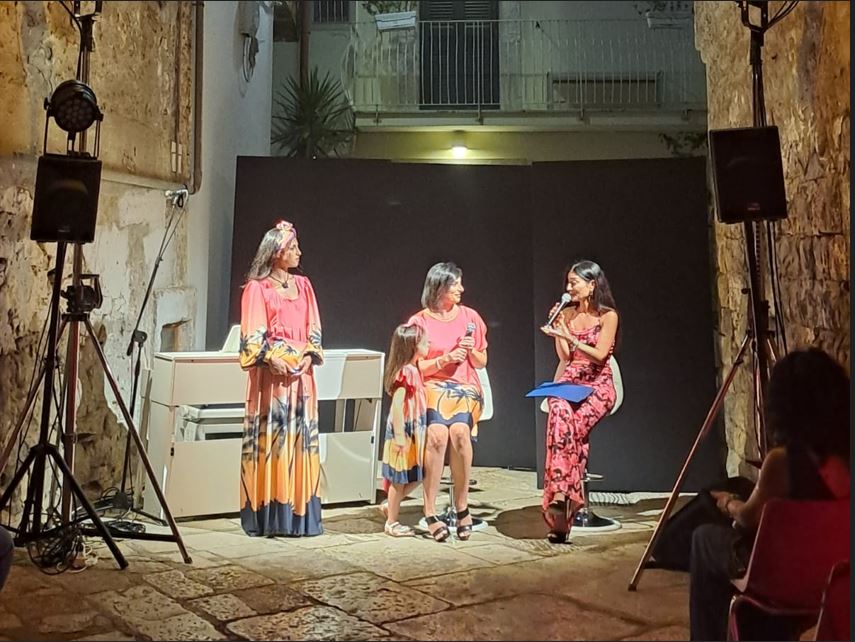 Artigianato e moda il tocco di Minerva compie dieci anni - nella foto tre donne vestite con giubba roasa parlano