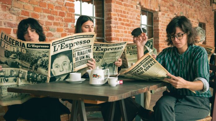 balletti verdi - le tre componenti la band viadellironia sedute al tavolo di un'osteria, intente a leggere dei quotidiani cartacei