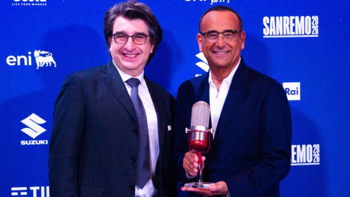 carlo conti in primo piano mentre riceeve il premio assomusica