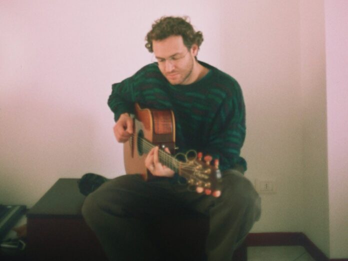 emit - kisskand - il cantautore intendo a suonare una chitarra acustica