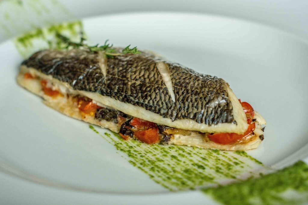 un pesce senza testa ne coda cucinato è farcito con pomodorini