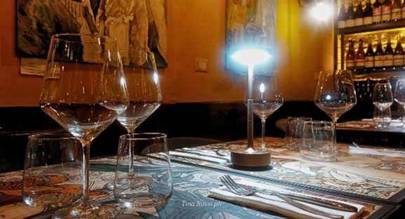 cucina romana - dei tavoli appparecchiatic on piatti e bicchieri con luci soffuse