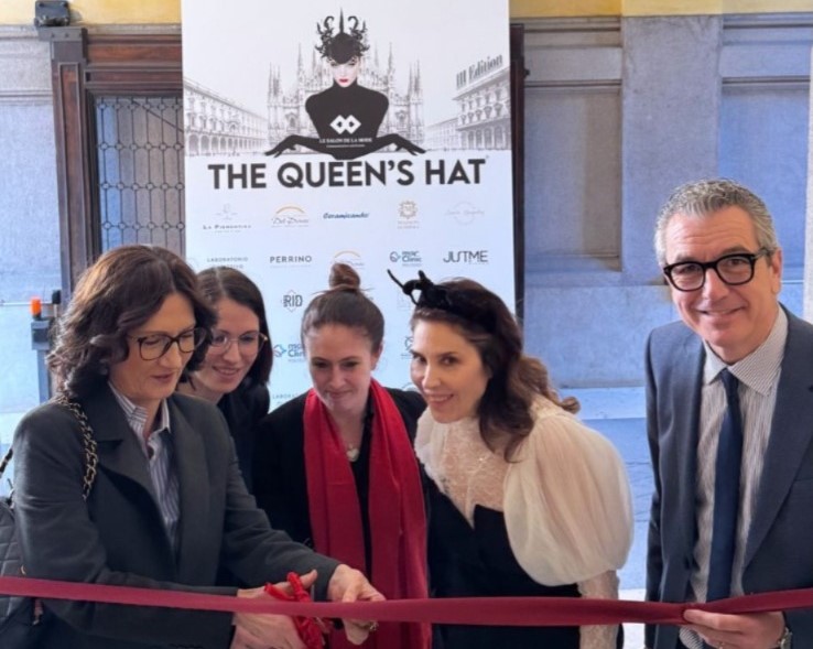 The Queen's Hat - delle persone ben vestite e una sta tagliando un nastro rosso con le forbici