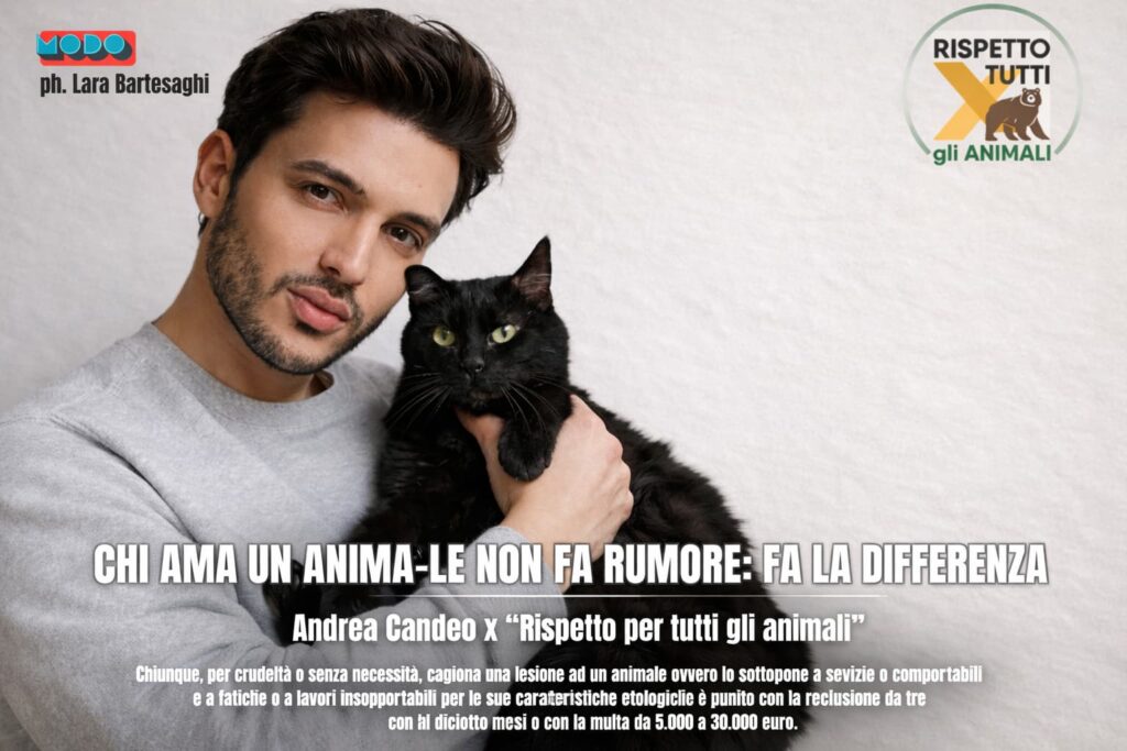 Andrea Candeo con maglia bianca a maniche lunghe abbraccia un gatto nero