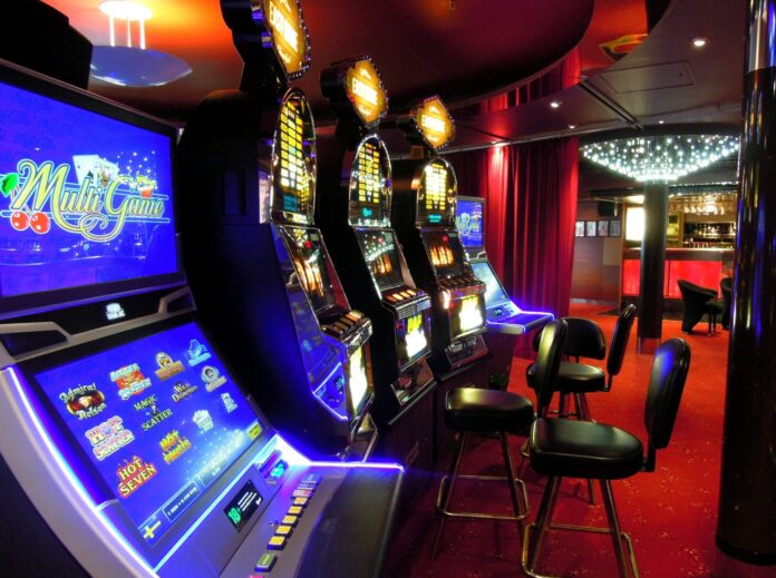 Gioco Responsabile ludopatia - nella foto una sala di un bar con tante slot machine e degli sgabelli neri