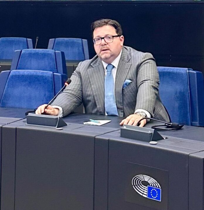 Sovraindebitamento, l’U.C.I. entra nell’European Consumer Debt Network - un uomo in giacca e cravatta, indossa occhiali da vista, ha la barba e sta parlando al tavolo conferenze