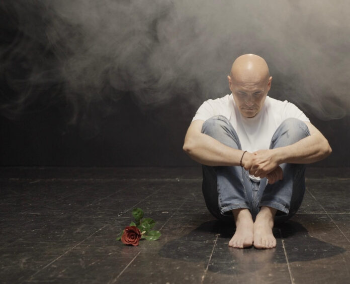 “Radici (23)” il nuovo singolo che racconta la vita e la musica di Stefano Sani -- Zetatielle Magazine stefano sani - radici 23 - il cantautore è seduto contro un muro, pantaloni scuri, t-shirt bianca, a piedi nudi, al suo fianco un fiore rosso