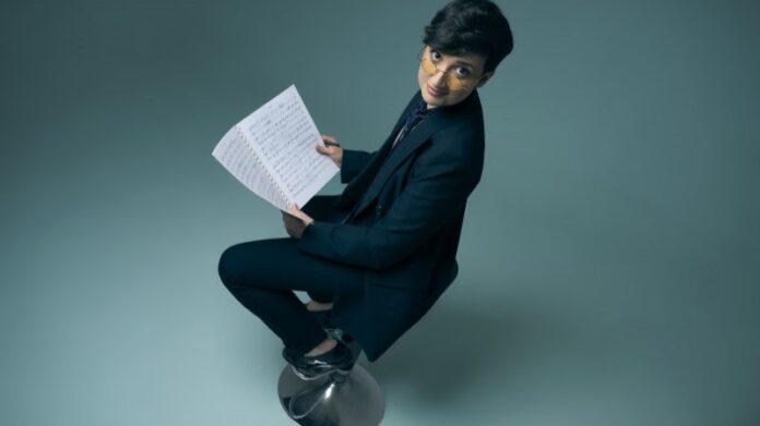 simona rosati in primo piano, seduta su uno sgabello con degli spartiti tra le mani