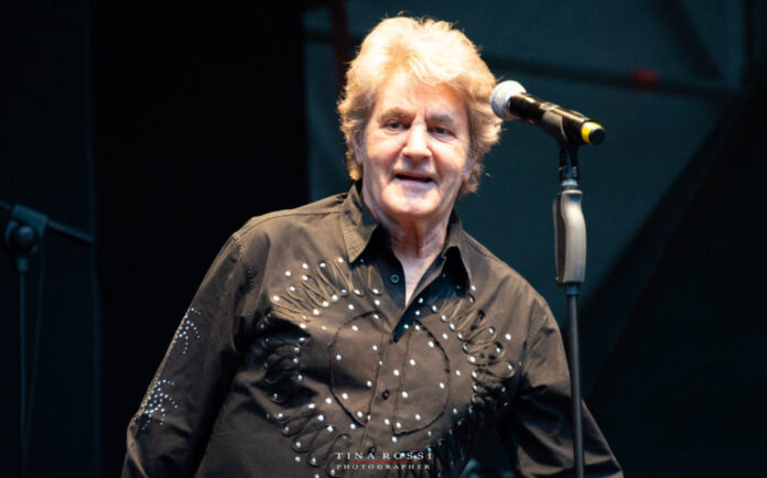 Canzonissima terza puntata Fausto Leali nella foto con camicia beige vicino a un microfono sorride