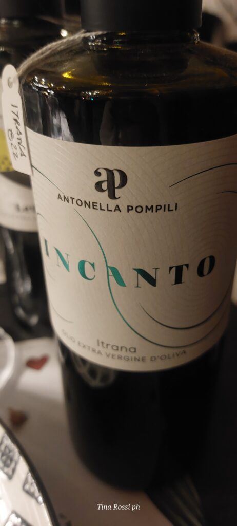 una bottiglia d'olio con etichetta bianca con scritte verdi