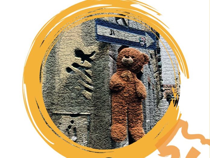 Gioele Urso - la copertina del libro con al centro un cerchio giallo con sfondo nero e nel cerchio un muro di citta con appeso un orsetto di peluches e sopra l orsetto una freccia segnaletica stradale