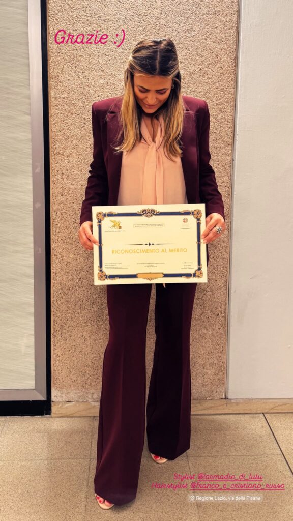michelle marie castiello con in mano il roconoscimento al merito del leone d'oro di venezia