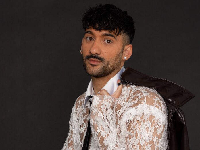 roccuzzo - piante finte - il cantante indossa una camicia bianca a disegni floreali trasparenti