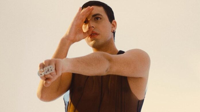“Scacciapensieri”, Giovanni Segreti Bruno tra folk mediterraneo ed elettronica -- Zetatielle Magazine scacciapensieri - giovanni segreti bruno in primo piano indossa una canotta marrone a rete