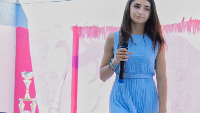 Marghe Piccola Popstar è il nuovo singolo - Zetatielle Magazine - Immagine1 marghe in primo piano, indossa un vestito azzurro e tiene il microfono nella mano destra
