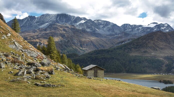 puglia - un paesaggio di montagna con un rifugio solitario sul pendio vicino a un torrente